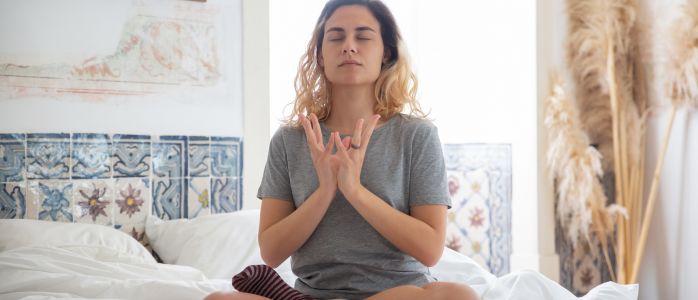A person meditating in a comfortable position with eyes closed, maintaining a consistent meditation practice